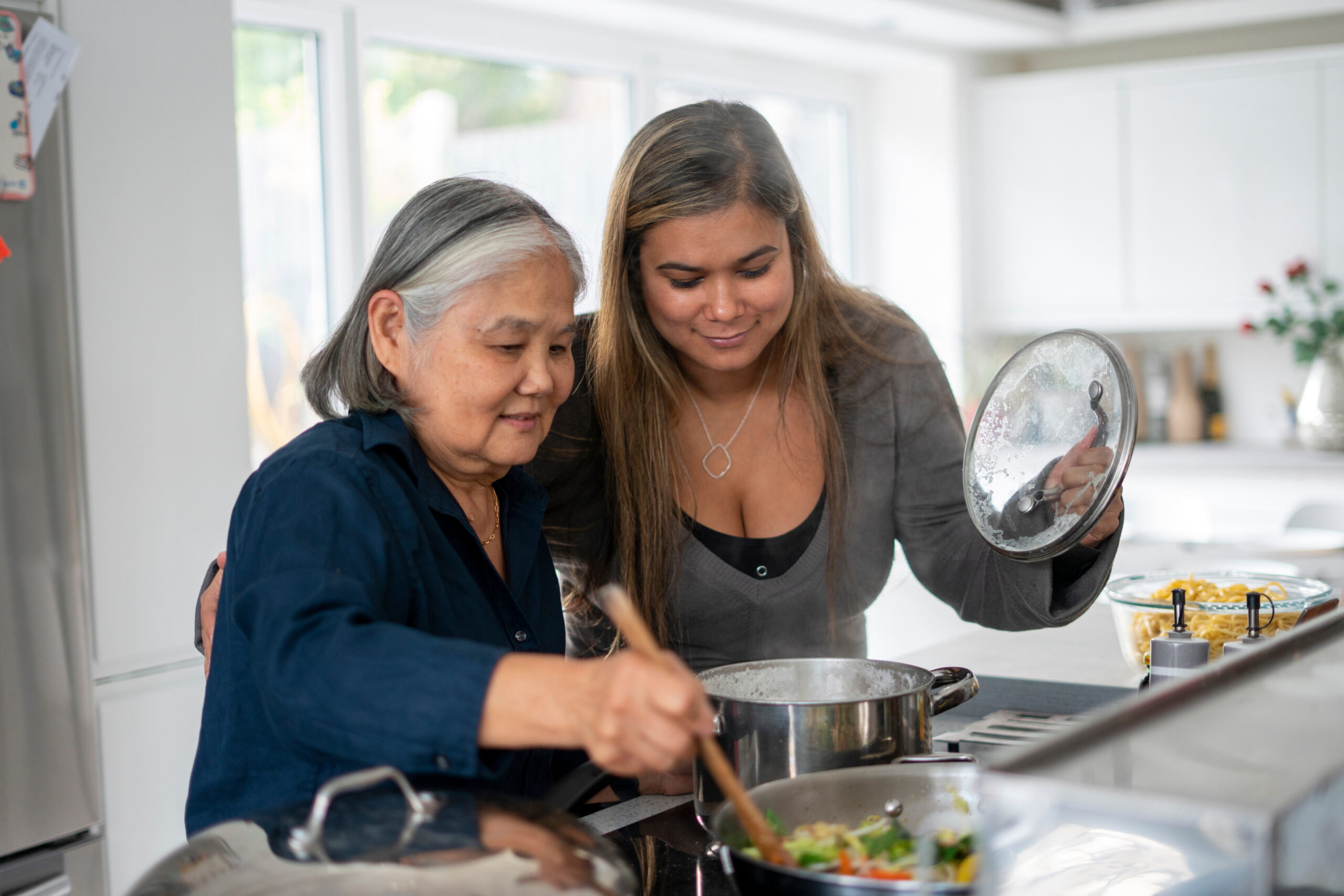 Two women prepare a nutritious meal in a modern home kitchen.
